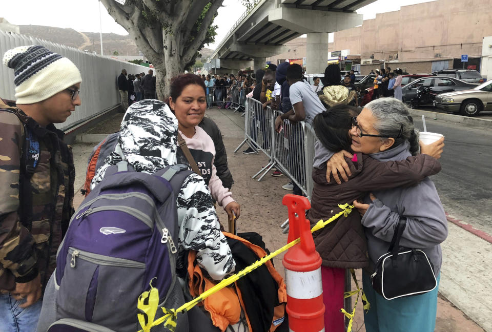 FILE - In this Thursday, Sept. 26, 2019, file photo, Luz Bertila Zazueta, 75, of Tijuana, right, hugs farewell to a Peruvian woman and her four children whose numbers were called to claim asylum at a border crossing in San Diego. A federal judge ruled Thursday, Sept. 2, 2021 that the U.S. government's practice of denying migrants a chance to apply for asylum on the Mexican border until space opens up to process claims is unconstitutional.(AP Photo/Elliot Spagat, File)