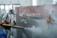 Volunteers from the Blue Sky Rescue team disinfect at the Qintai Grand Theatre in Wuhan