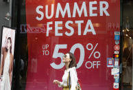 A woman passes by a sale sign at a shopping district in Seoul, South Korea, Thursday, July 18, 2019. South Korea's central bank on Thursday cut its policy rate for the first time in three years to shore up growth threatened by a trade dispute with Japan. (AP Photo/Ahn Young-joon)