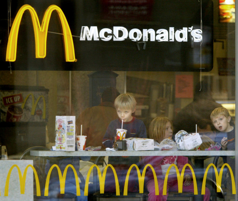 Children peer out the window while eating hamburgers in a Chicago McDonald's restaurant, December 26, 2003. The U.S. Agriculture Department said on Friday it quarantined a second herd in Washington state as part of its investigation into the nation's first case of mad cow disease. Restaurant shares edged higher after sliding earlier this week on fears that consumers will shy away from beef because of of the mad cow case. McDonald's gained 13 cents to $24.09. CPROD REUTERS/John Gress  JG/GN