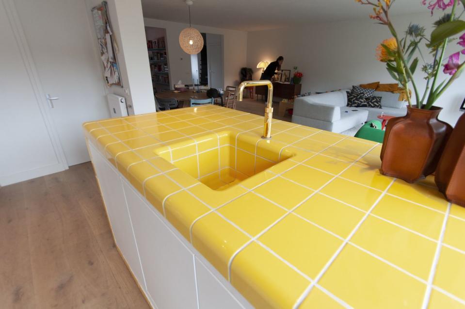 a room with a yellow and white tile floor and a couch