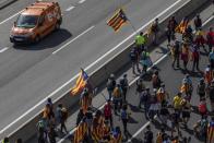 Catalan pro-independence demonstrators march near Navas, Spain, Wednesday, Oct. 16, 2019. Thousands of people have joined five large protest marches across Catalonia that are set to converge on Barcelona, as the restive region reels from two straight days of violent clashes between police and protesters. The marches set off from several Catalan towns and aimed to reach the Catalan capital by Friday. (AP Photo/Bernat Armangue)