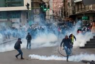 People react amid tear gas during clashes between members of the security forces and supporters of former Bolivian President Evo Morales in La Paz