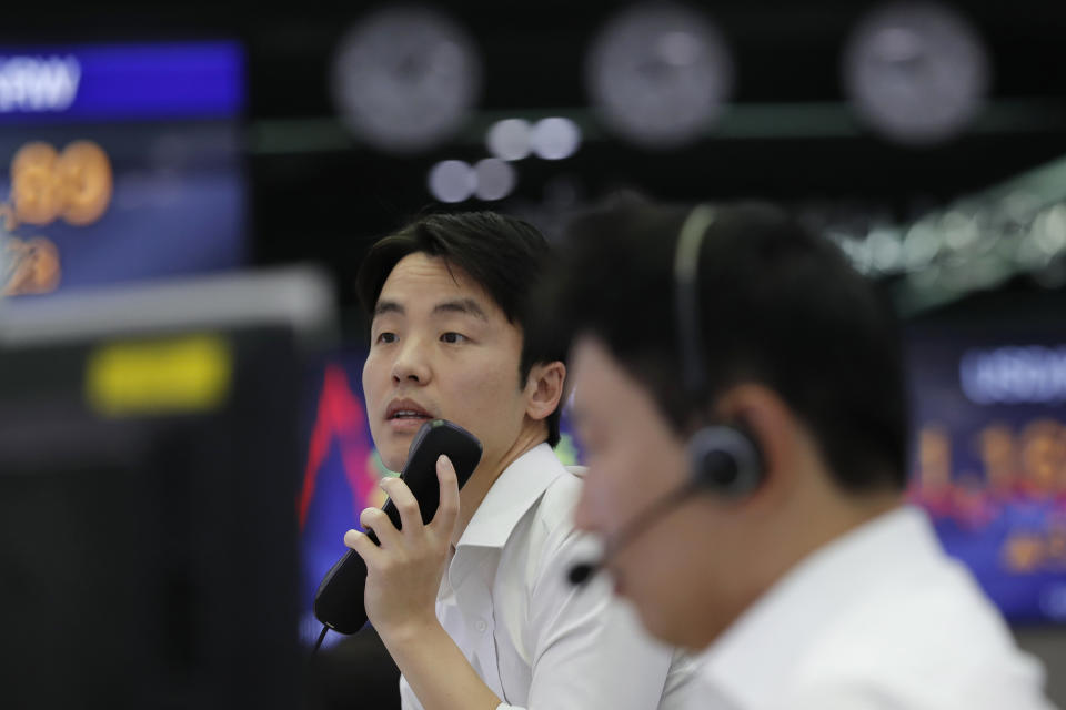 A currency trader holds a phone at the foreign exchange dealing room in Seoul, South Korea, Thursday, Nov. 7, 2019. Asian stocks are mostly lower after a meandering day of trading left U.S. stock indexes close to their record highs. (AP Photo/Lee Jin-man)