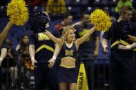 Michigan cheerleaders perform before an NCAA Midwest Regional semifinal college basketball tournament game between the Michigan and the Tennessee Friday, March 28, 2014, in Indianapolis. (AP Photo/David J. Phillip)