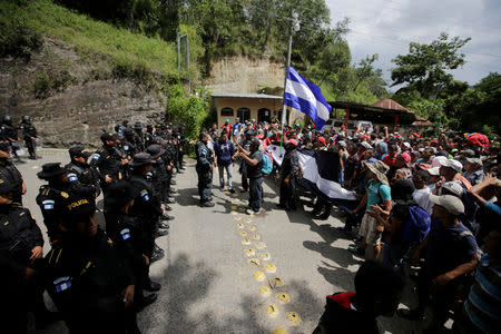 Guatemala's police officers stand as Honduran migrants, part of a caravan trying to reach the U.S., arrive to the border between Honduras and Guatemala, in Agua Caliente, Guatemala October 15, 2018. REUTERS/Jorge Cabrera