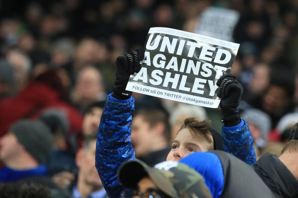 A Newcastle supporter holds up a sign against owner Mike Ashley before a Premier League game against Manchester City at St. James' Park in 2019. (Photo by Lindsey Parnaby/AFP via Getty Images)