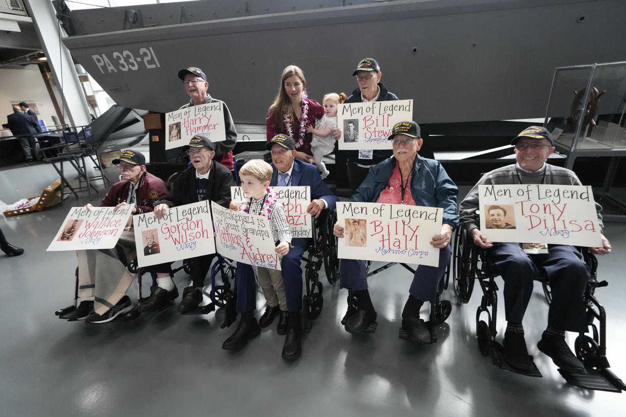 World War II veteran Joseph Eskenazi, who at 104 years and 11 months old is the oldest living veteran to survive the attack on Pearl Harbor, sits with fellow veterans and his great grandchildren Mathias, 4, and Audrey, 1, at an event celebrating his upcoming 105th birthday at the National World War II Museum in New Orleans, Wednesday, Jan. 11, 2023. (AP Photo/Gerald Herbert)
