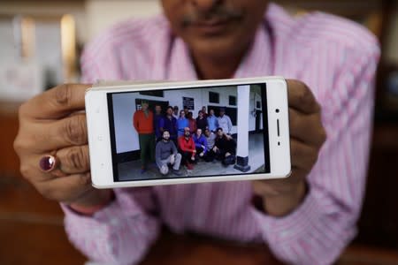 C.S. Pandey, Managing Director of the Himalayan Run & Trek Pvt. Ltd., shows a group photograph of the climbers before leaving for their expedition from Munsiyari town in the northern Himalayan state of Uttarakhand, at his office in New Delhi