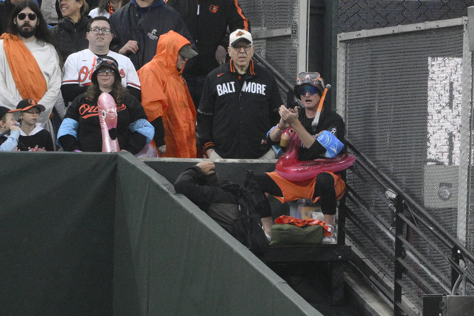 Baltimore Orioles owner David Rubenstein, second from right, stands next to 'Mr. Splash," right, during a baseball game between the Orioles and the Arizona Diamondbacks, Friday, May 10, 2024, in Baltimore. (AP Photo/Nick Wass)