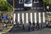 Security personnel march to their duty outside the Evergrande headquarters in Shenzhen, China, Friday, Sept. 24, 2021. Seeking to dispel fears of financial turmoil, some Chinese banks are disclosing what they are owed by the real estate developer that is struggling under $310 billion in debt, saying they can cope with a potential default.(AP Photo/Ng Han Guan)