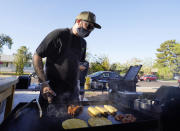 Chef Mike Winneker prepares food in front of his home Saturday, April 3, 2021, in Scottsdale, Ariz. Beaten down by the pandemic, many laid-off or idle restaurant workers have pivoted to dishing out food with a taste of home. Some have found their entrepreneurial side, slinging their culinary creations from their own kitchens. (AP Photo/Ross D. Franklin)