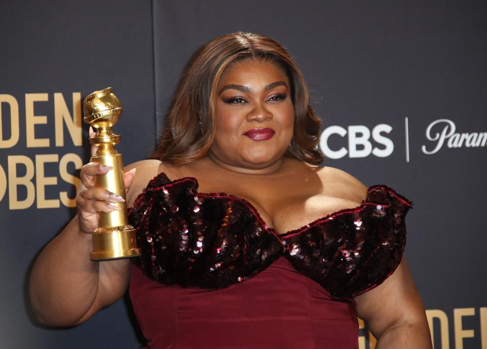 Da'Vine Joy Randolph hoists her Golden Globe for supporting actress for "The Holdovers."