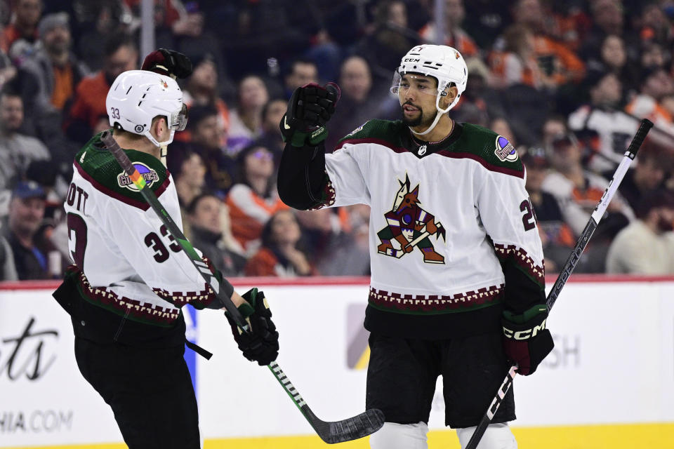 Arizona Coyotes' Matt Dumba, right, celebrates with Travis Dermott after scoring during the first period of an NHL hockey game against the Philadelphia Flyers, Monday, Feb. 12, 2024, in Philadelphia. (AP Photo/Derik Hamilton)