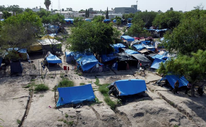 Asylum seekers wait at a makeshift camp to attempt to cross into the U.S., in Matamoros