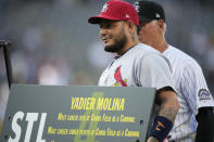 St. Louis Cardinals catcher Yadier Molina holds one of his gifts given by the Colorado Rockies to mark his retirement before the first inning of a baseball game Tuesday, Aug. 9, 2022, in Denver. (AP Photo/David Zalubowski)