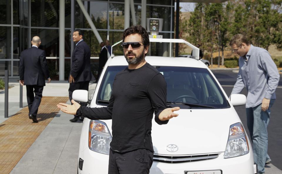 FILE - In this Sept. 25, 2012, file photo, Google co-founder Sergey Brin gestures after riding in a driverless car with officials, to a bill signing for driverless cars at Google headquarters in Mountain View, Calif. Google engineers say they have turned a corner in their pursuit of creating a car that can drive itself. Test cars have been able to navigate freeways comfortably for a few years. On Monday, April 28, 2014, Google said the cars can now negotiate thousands of urban situations that would have stumped them a year or two ago. (AP Photo/Eric Risberg, File)