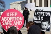 FILE PHOTO: A police officer watches demonstrators on the anniversary of the Supreme Court's 1973 Roe v. Wade abortion decision in Washington