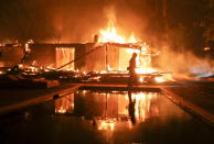 <p>Tim Billow, 62, tries to save his plantings in his backyard as the Woolsey Fire burns in Malibu, Calif., Friday, Nov. 9, 2018.<br>A southern California wildfire continues to burn homes as it runs toward the sea. Winds are blamed for pushing the fire through scenic canyon communities and ridgetop homes.<br>(Photo from Ringo H.W. Chiu, AP) </p>