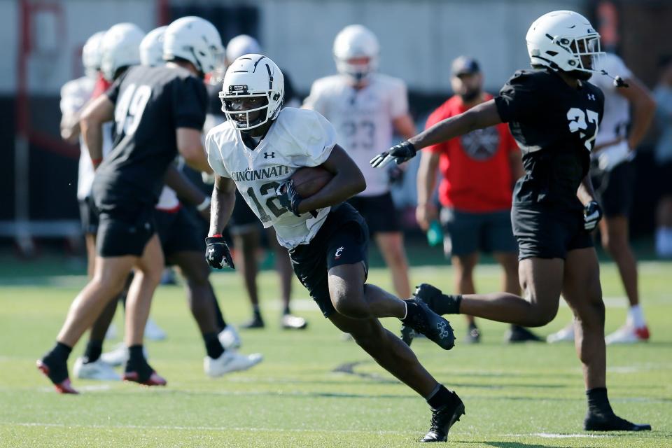 Bearcats receiver Quincy Burroughs (12) runs with a catch during the first day of preseason training camp at the University of Cincinnati's Sheakley Athletic Complex in Cincinnati on Wednesday, Aug. 3, 2022.