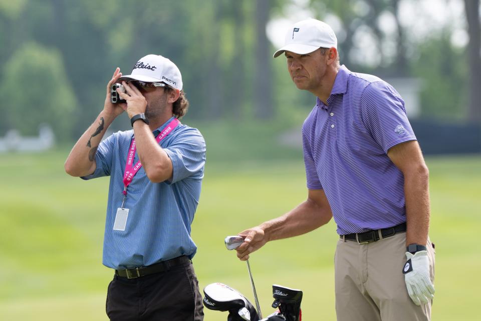 Jared Jones and his caddie Tyler Seymore check the distance from the cup on the 12th hole at Valhalla Golf Club during the first practice day on Monday, May 13, 2024.