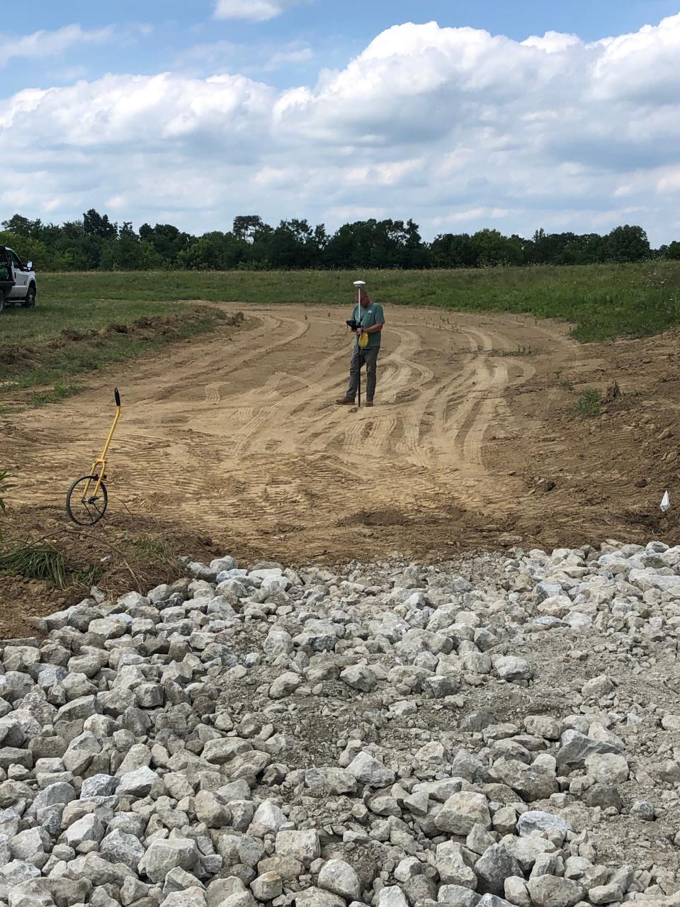 The Soil & Water Conservation District works to eliminate soil erosion on farms by building grass waterways in fields. Seen here is a waterway being built and inspected before the grass is planted.