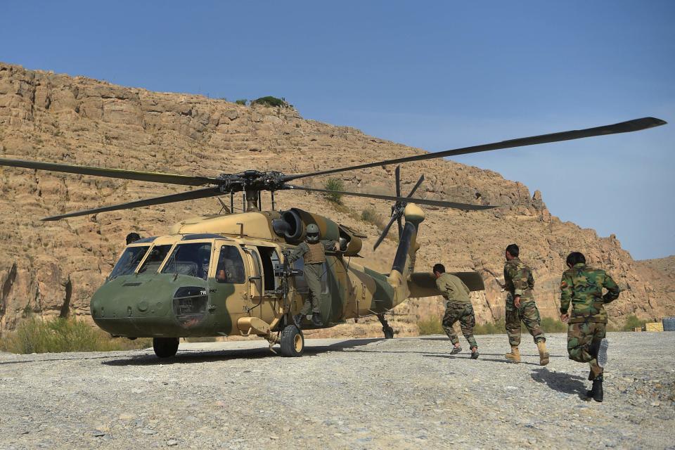 (FILES) In this file photo taken on March 25, 2021 Afghan National Army (ANA) soldiers unload food items and petrol oil from an Afghan Air Force Black Hawk helicopter at the hydroelectric Kajaki Dam in Kajaki, northeast of Helmand Province.