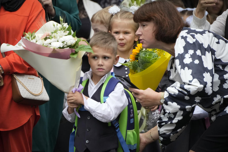 First graders enter a school yard to take part in a ceremony marking the start of classes at a school as part of the traditional opening of the school year known as "Day of Knowledge" in St. Petersburg, Russia, Friday, Sept. 1, 2023. Many schools across the country reopen on Sept. 1. (AP Photo/Dmitri Lovetsky)
