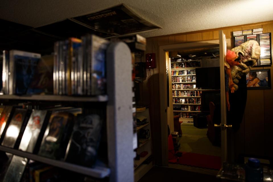 7,000 movies and accompanying promo materials line the walls and ceiling of Brian and Erin Hogan's basement on Thursday, March 11, 2021, in Urbandale, IA. A movie enthusiast since he was a kid, Brian started collecting the movies and got the shelves as video stores closed to store them. The homage to video stores materialized as their daughter moved out and the video store shelves moved in.