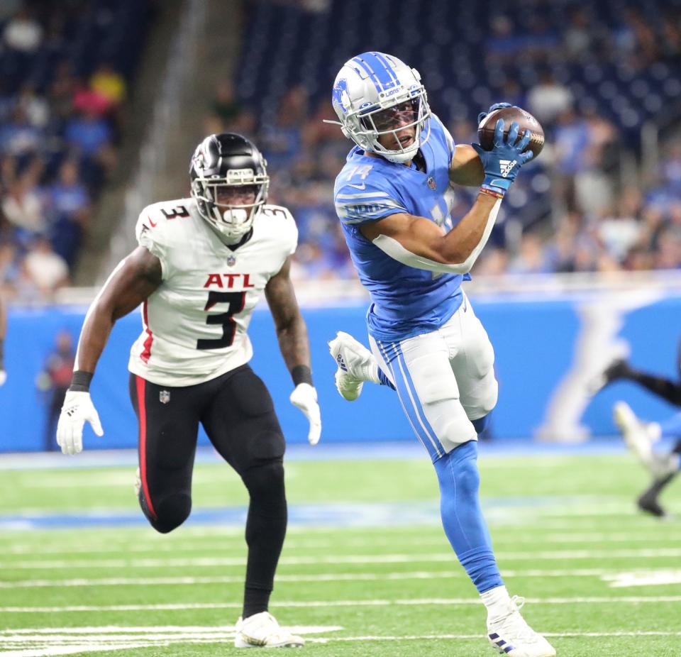 Lions wide receiver Amon-Ra St. Brown makes a catch against Falcons linebacker Mykal Walker (3) during the first half of a preseason game Aug.12, 2022 at Ford Field.