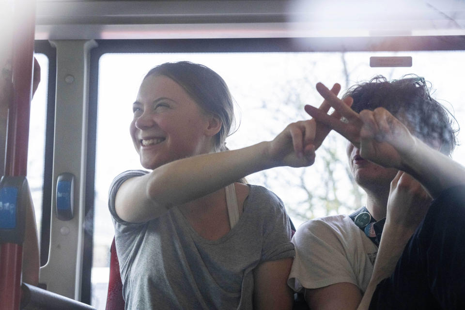 Climate activist Greta Thunberg flashes a V-sign after being detained and driven off in a bus after joining protestors who blocked a road during a climate protest of Extinction Rebellion and other activists near the Dutch parliament in The Hague, Netherlands, Saturday, April 6, 2024. (AP Photo/Peter Dejong)