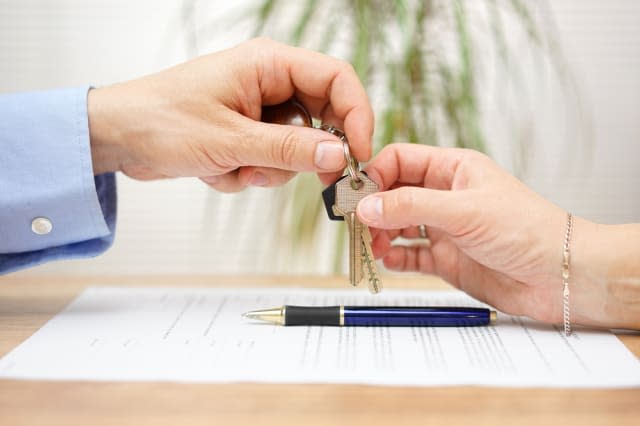 real estate agent gives house keys to his client