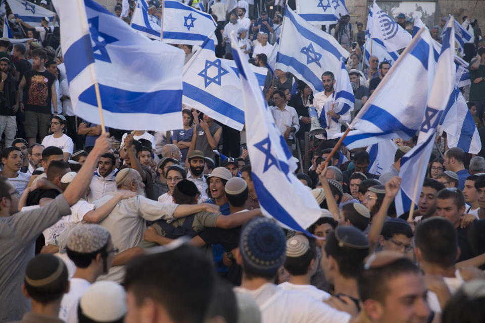 Far-right Israelis dance with Israeli flags as they march near Damascus Gate during the 