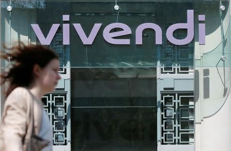 A woman walks walk past the main entrance of the entertainment-to-telecoms conglomerate Vivendi's headquarters in Paris April 8, 2015. REUTERS/Gonzalo Fuentes/File Photo