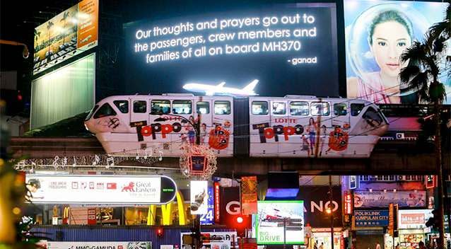 A message for passengers onboard the missing Malaysia Airlines Flight MH370 is seen on big screen in Kuala Lumpur. Photo: Reuters.