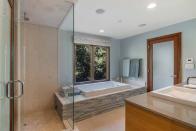 6) Another view of the master bathroom with a glass-enclosed shower and separate bathtub.
