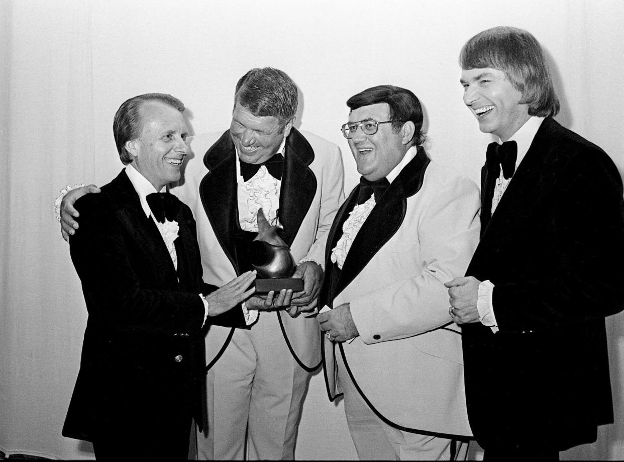 James Blackwood, left, and Cecil Blackwood, right, are congratulated by Jim Hamill, second form left, and Eldridge Fox of the Kingsmen on their receipt of the award for the Memphis-based Blackwood Brothers as being the Best Male Gospel Group of the Year during the annual Dove Awards show at the Grand Ole Opry House Sept. 30, 1974.