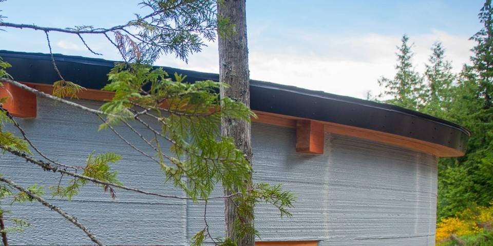 the exterior of the Fibonacci House among trees and grass