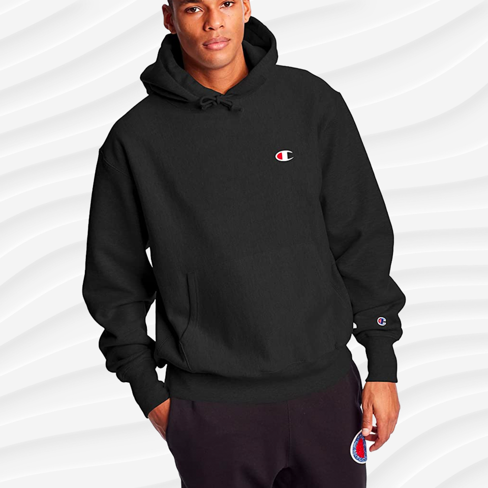 a man wearing the champion reverse weave hoodie in black