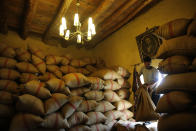 In this Saturday Sept. 8, 2018 photo, a worker carries bag of anise that is used to produce arak, Lebanon's national alcoholic drink, at the Doumaine de Tourelles winery, in the town of Chtaura, east Lebanon. Homemade arak usually goes straight into gallon containers after distillation, ready for drinking. In commercial production, the arak sits in clay jugs for a year, making it smoother. (AP Photo/Hussein Malla)