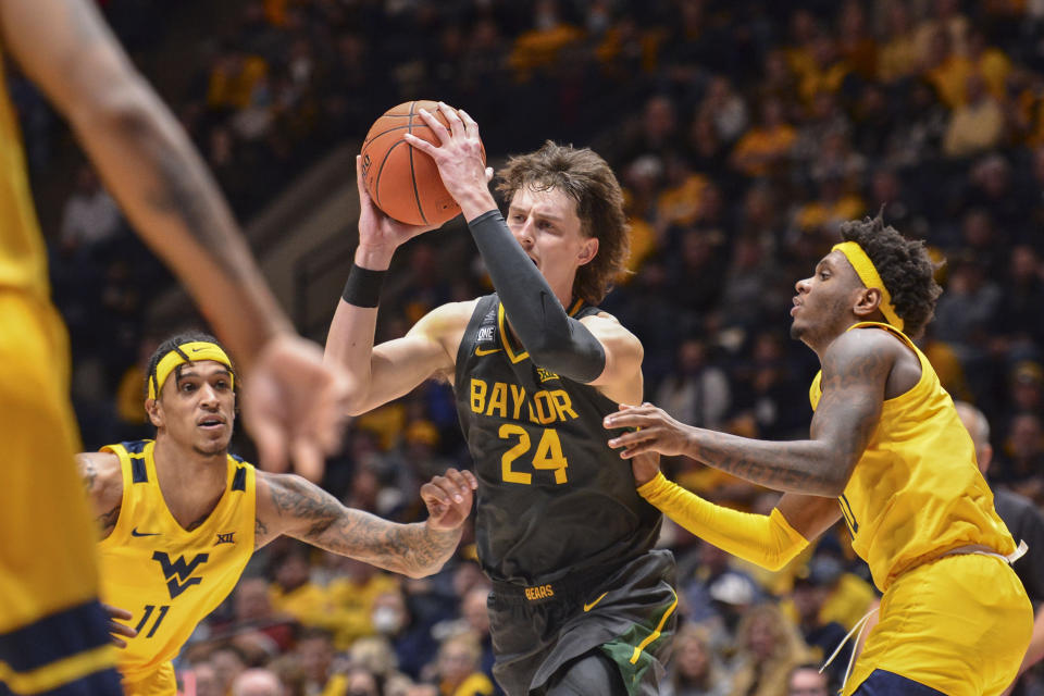 Baylor guard Matthew Mayer (24) makes a pass while being guarded by West Virginia forward Jalen Bridges (11) during the second half of an NCAA college basketball game in Morgantown, W.Va., Tuesday, Jan. 18, 2022. (William Wotring)