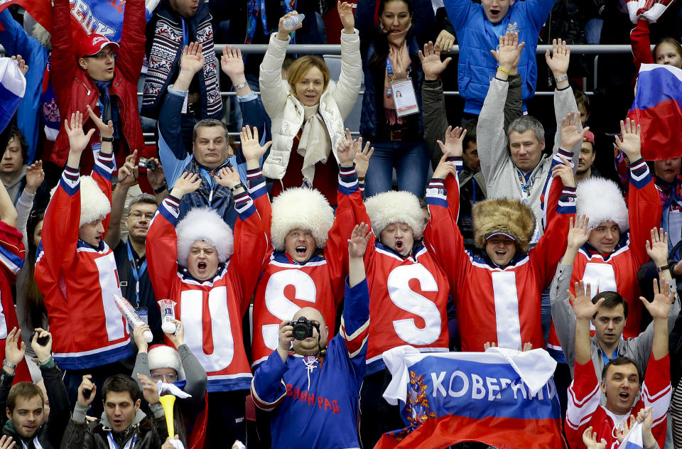 Russian hockey fans do the wave in the first period of a men's ice hockey game between Russia and Slovakia at the 2014 Winter Olympics, Sunday, Feb. 16, 2014, in Sochi, Russia. (AP Photo/Julio Cortez)