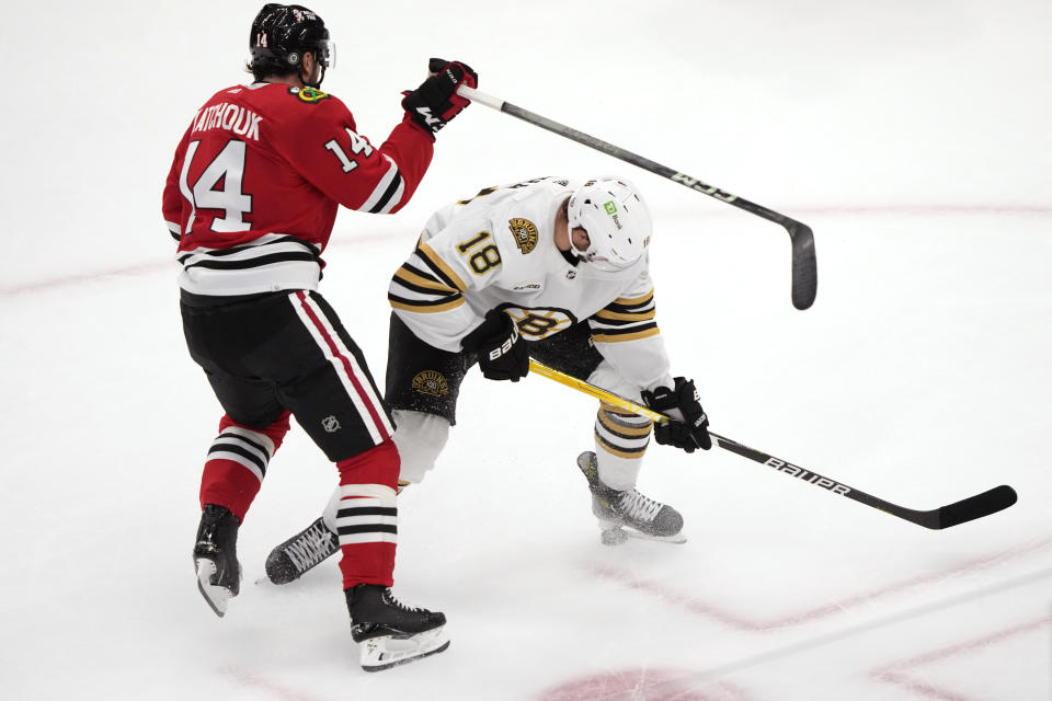 Boston Bruins' Pavel Zacha (18) stops the puck with his skate as Chicago Blackhawks' Boris Katchouk tries to maneuver around Zacha during the second period of an NHL hockey game Tuesday, Oct. 24, 2023, in Chicago. (AP Photo/Charles Rex Arbogast)