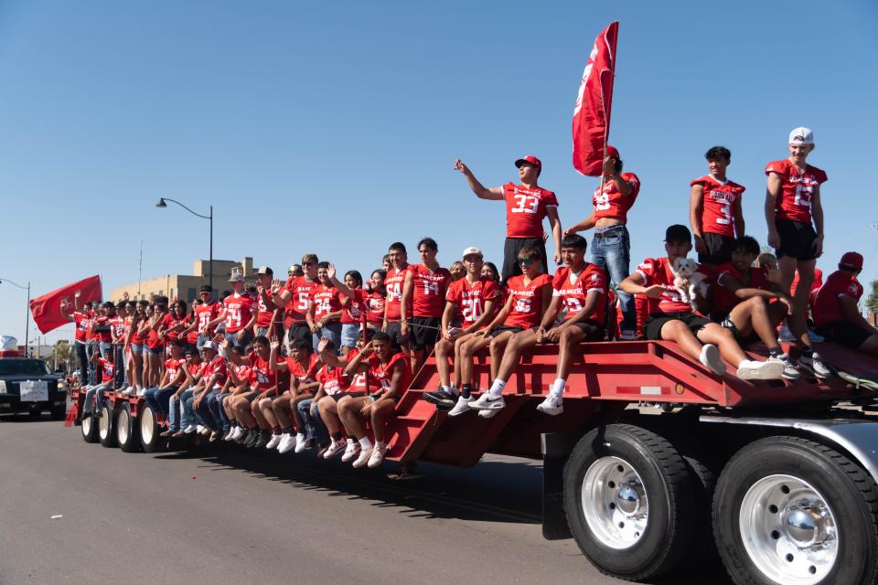 The Perryton High School football team waves to the crowd at the 104th annual Wheatheart of the Nation Parade Saturday in Perryton.