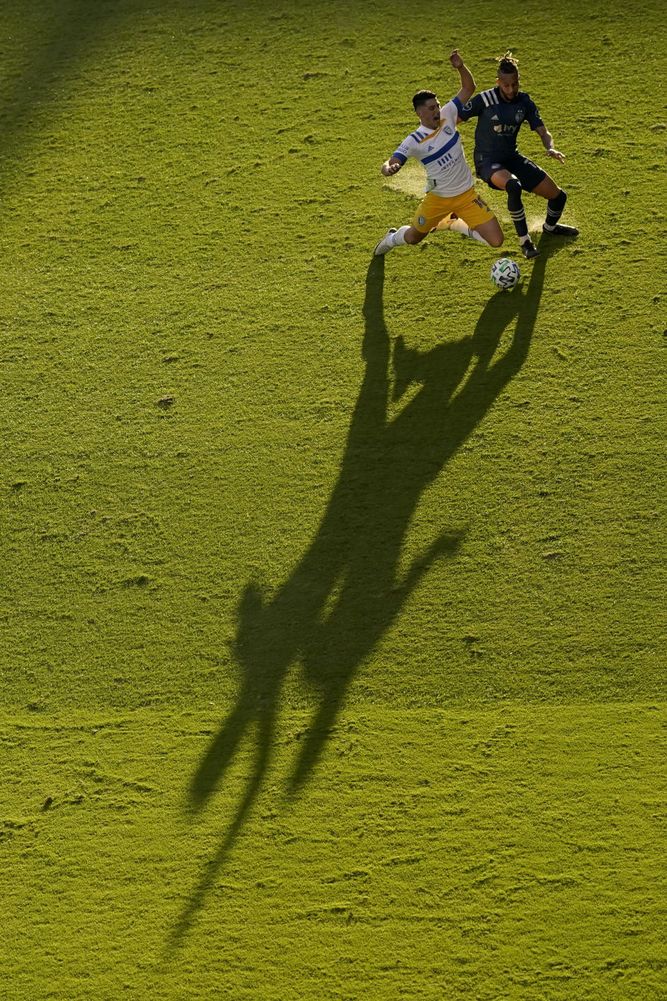 San Jose Earthquakes forward Cristian Espinoza, left, and Sporting Kansas City defender Amadou Dia battle for the ball during the first half of an MLS soccer match Sunday, Nov. 22, 2020, in Kansas City, Kan. (AP Photo/Charlie Riedel)