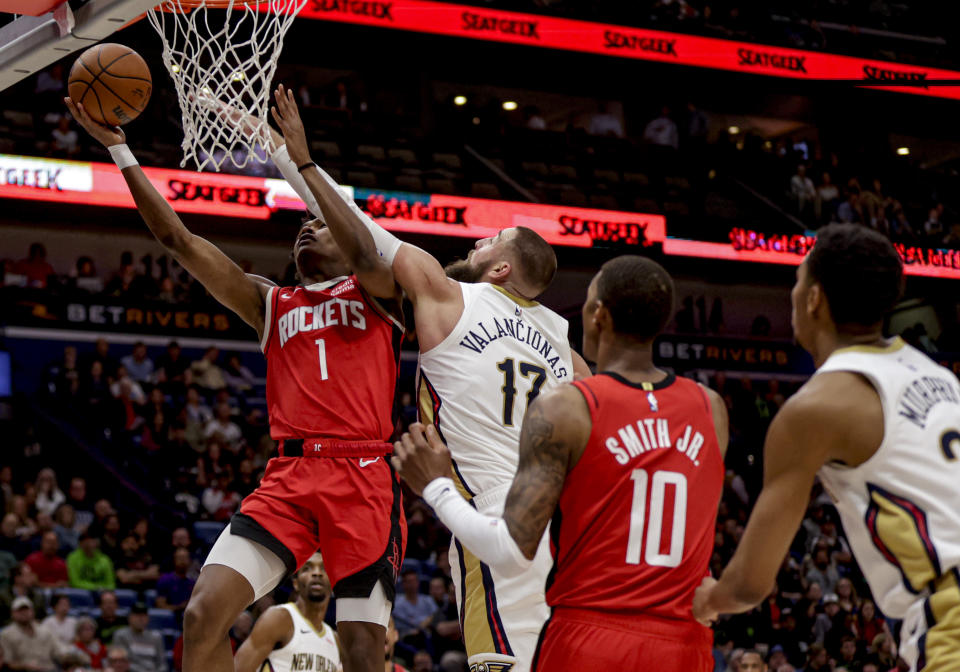 Houston Rockets forward Amen Thompson (1) shoots next to New Orleans Pelicans center Jonas Valanciunas (17) in the first half of an NBA basketball game in New Orleans, Thursday, Feb. 22, 2024. (AP Photo/Derick Hingle)