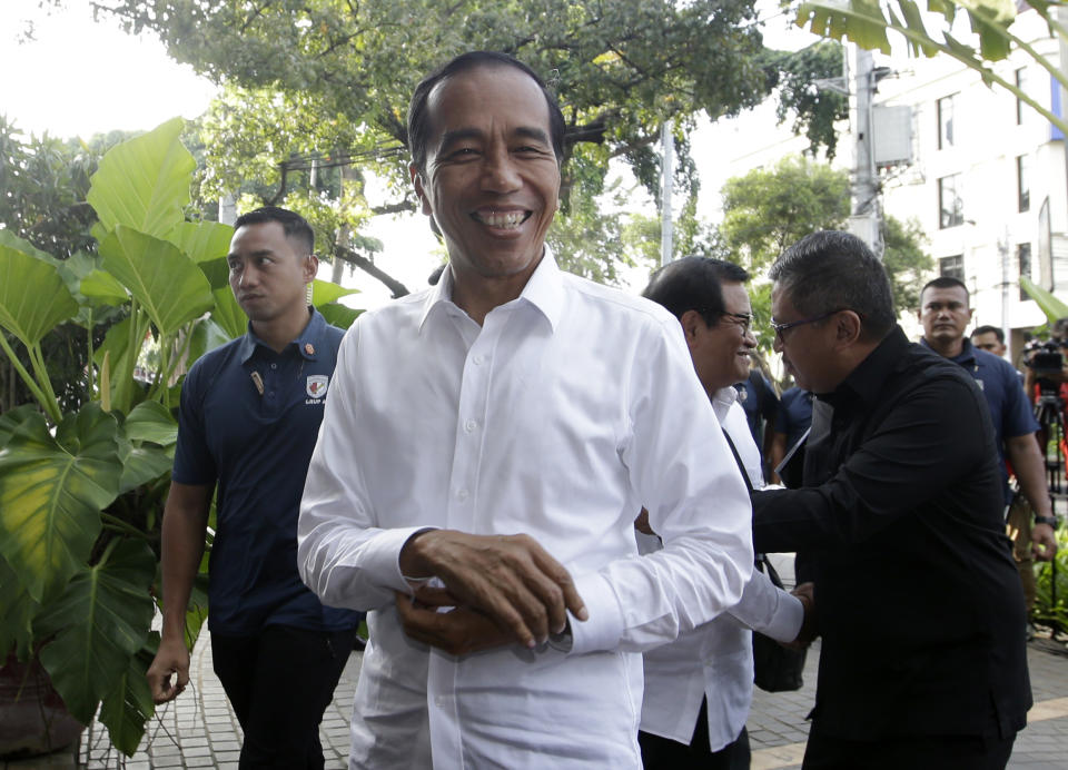 Incumbent Indonesian President Joko Widodo, center, smiles upon arrival for a meeting with leaders of his coalition parties in Jakarta, Indonesia, Thursday, April 18, 2019. Widodo said Thursday he was won re-election after receiving an estimated 54% of the vote, backtracking on an earlier vow to wait for official results after his challenger made improbable claims of victory. (AP Photo/Achmad Ibrahim)