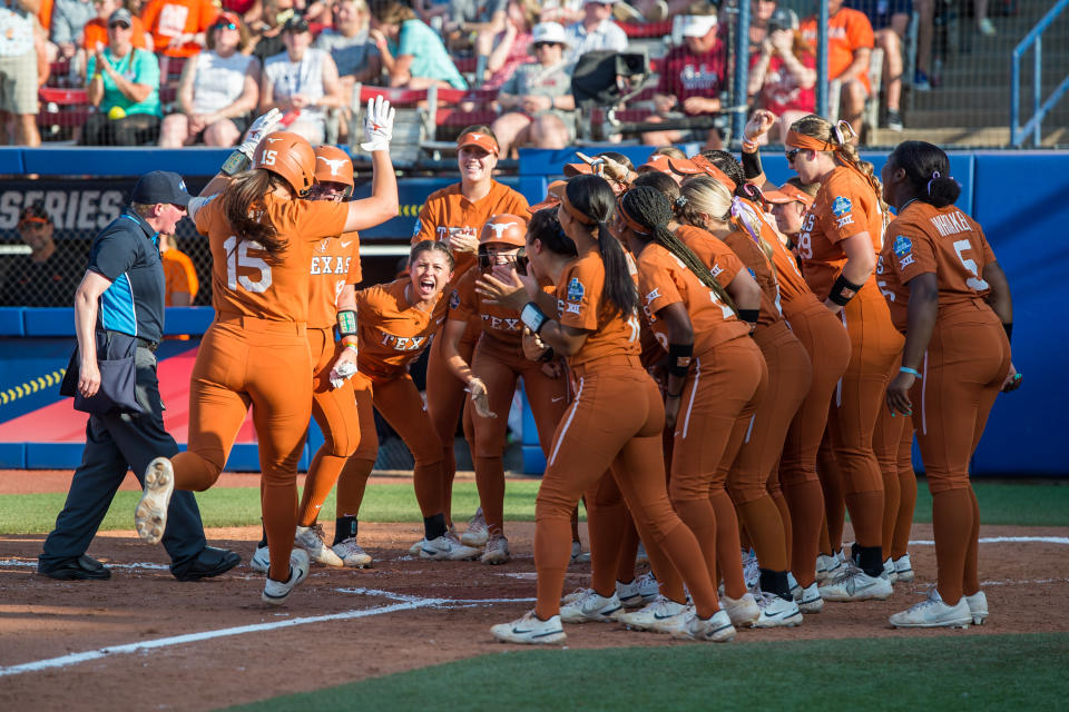 June 6, 2022; Oklahoma City, Oklahoma, USA; Texas Longhorns players dp Courtney Day (15) during the second NCAA Women's College World Series game with Oklahoma State Cow Girls at the US Softball Hall of Fame Stadium. ) Gather around the home plate after hitting a 3-run home run. Texas won 5-0 and forced a second game to decide who would go to the final against Oklahoma. Required Credits: Brett Rojo-USA TODAY Sports
