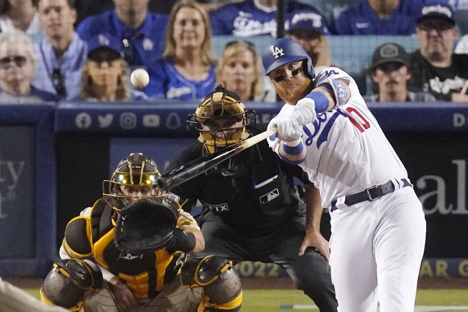 Los Angeles Dodgers' Justin Turner, right, hits a two-run home run as San Diego Padres catcher Austin Nola, left, watches along with home plate umpire Dan Iassogna during the seventh inning of a baseball game Thursday, June 30, 2022, in Los Angeles. (AP Photo/Mark J. Terrill)