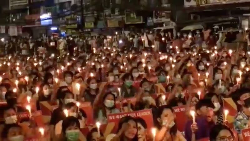 People take part in a candlelight gathering in Yangon